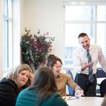 Five people laughing and having a conversation